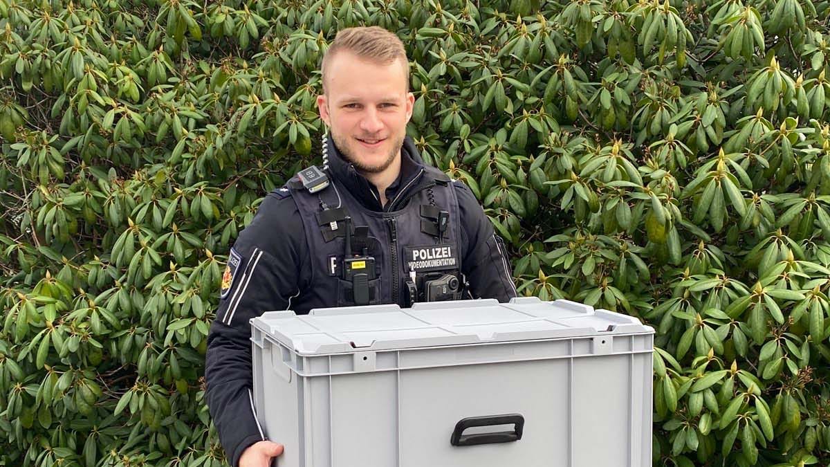 Ein Beamter der Polizei hält eine Transportbox, in der sich die Spinne befindet: Es muss noch geklärt werden, ob es sich tatsächlich um eine giftige Spinne handelt.