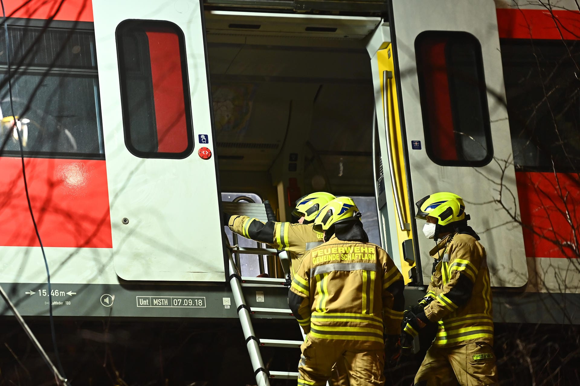 Feuerwehrleute befestigen eine Leiter an einem der verunfallten S-Bahnwagen.