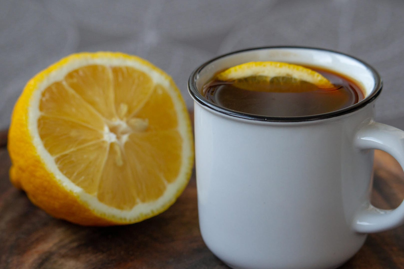 Tasse Kaffee mit einer halben Zitrone: Viele Kopfschmerzgeplagte schwören auf Kaffee mit Zitrone. Einen Versuch ist die ungewöhnliche Kombi wert.