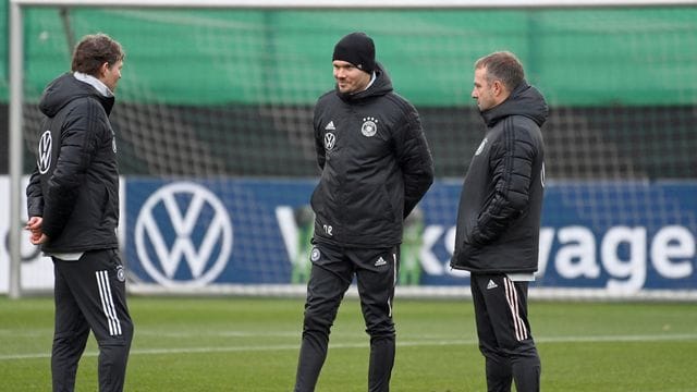 Trainer Hansi Flick (r) unterhält sich mit den Co-Trainern Marcus Sorg (l) und Danny Röhl. Trainer Hansi Flick (r) unterhält sich mit den Co-Trainern Marcus Sorg (l) und Danny Röhl.