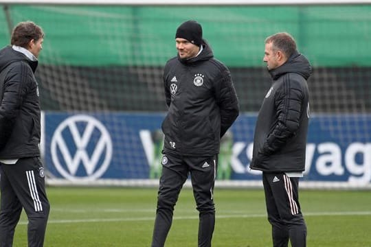 Trainer Hansi Flick (r) unterhält sich mit den Co-Trainern Marcus Sorg (l) und Danny Röhl.