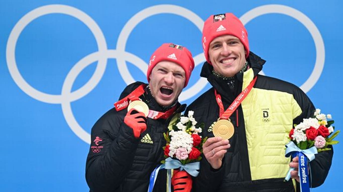 Francesco Friedrich (l) und Thorsten Margis freuen sich bei der Siegerehrung über olympisches Gold.