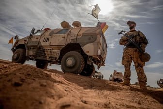Ein Soldat der Bundeswehr steht in Mali neben einem Militärfahrzeug.