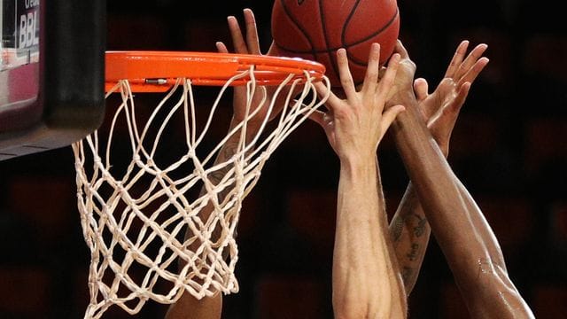 Spieler zweier Basketballmannschaften gehen zum Rebound