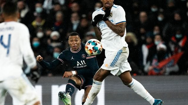 Kylian Mbappe (M) von Paris Saint-Germain (M) kommt gegen einen Abwehrversuch von Reals Eder Militao zum Schuss.