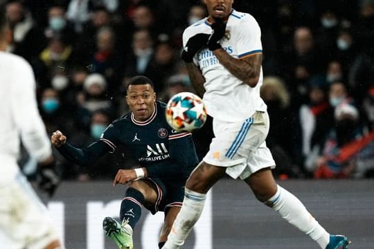 Kylian Mbappe (M) von Paris Saint-Germain (M) kommt gegen einen Abwehrversuch von Reals Eder Militao zum Schuss.