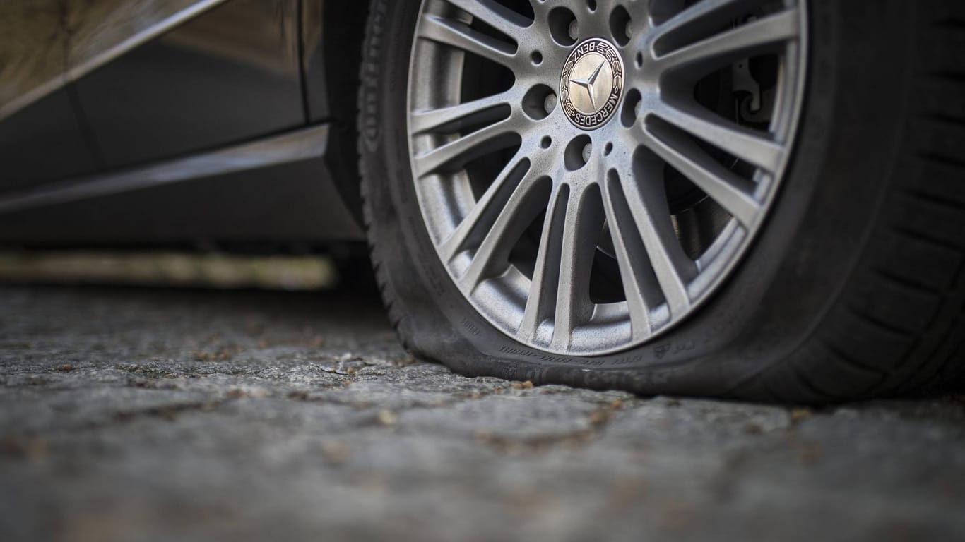 Ein platter Reifen an einer Luxuskarosse (Archivbild): In Berlin haben vermutlich Umweltaktivisten Luft aus den Reifen von 150 Fahrzeugen gelassen.