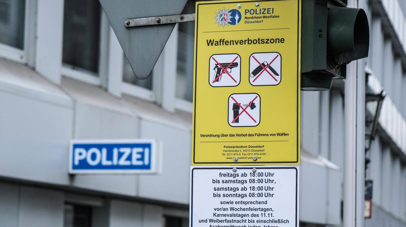 Ein Waffenverbotszonenschild vor einer Polizeiwache in der Düsseldorfer Altstadt (Archivbild): An mehreren Bahnhöfen in NRW werden weitere Waffenverbotszonen eingerichtet.