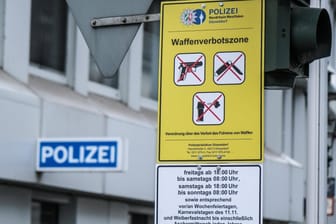 Ein Waffenverbotszonenschild vor einer Polizeiwache in der Düsseldorfer Altstadt (Archivbild): An mehreren Bahnhöfen in NRW werden weitere Waffenverbotszonen eingerichtet.