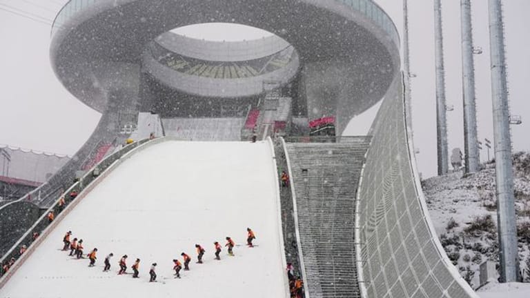 Mitarbeiter präparieren die Schanze im Skisprungzentrum Zhangjiakou.