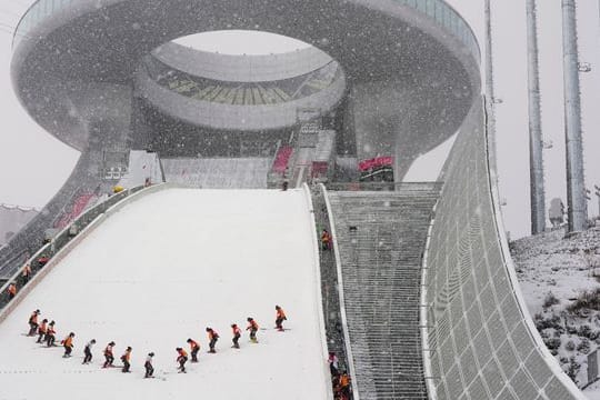 Mitarbeiter präparieren die Schanze im Skisprungzentrum Zhangjiakou.