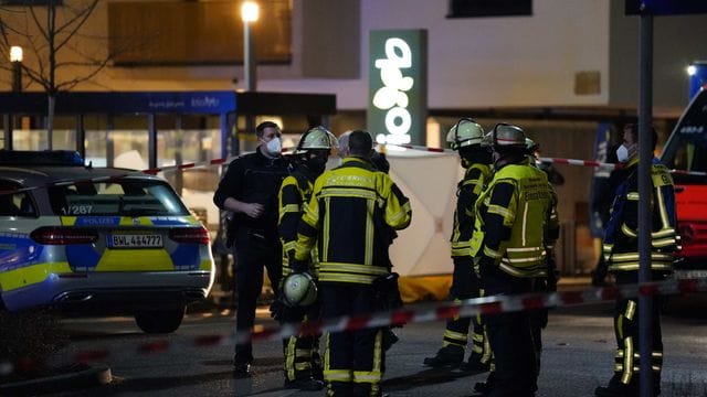 Polizisten und Feuerwehr stehen an einem Supermarkt