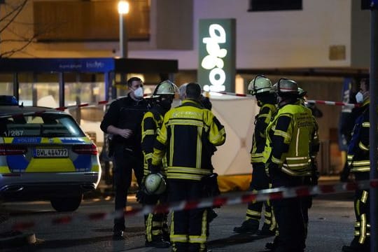 Polizisten und Feuerwehr stehen an einem Supermarkt