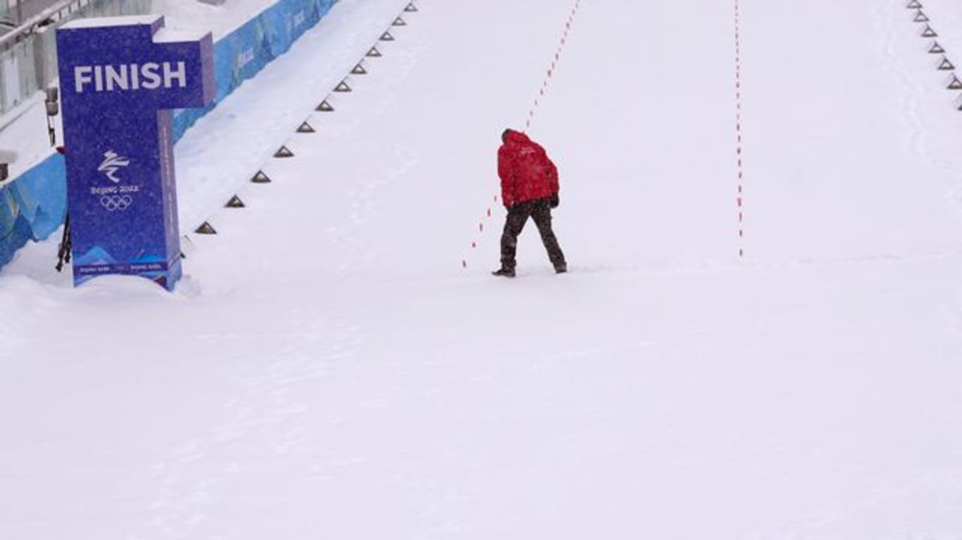 Ein Offizieller versucht die Ziellinie von Schnee zu befreien.