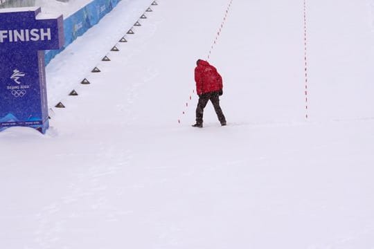 Ein Offizieller versucht die Ziellinie von Schnee zu befreien.