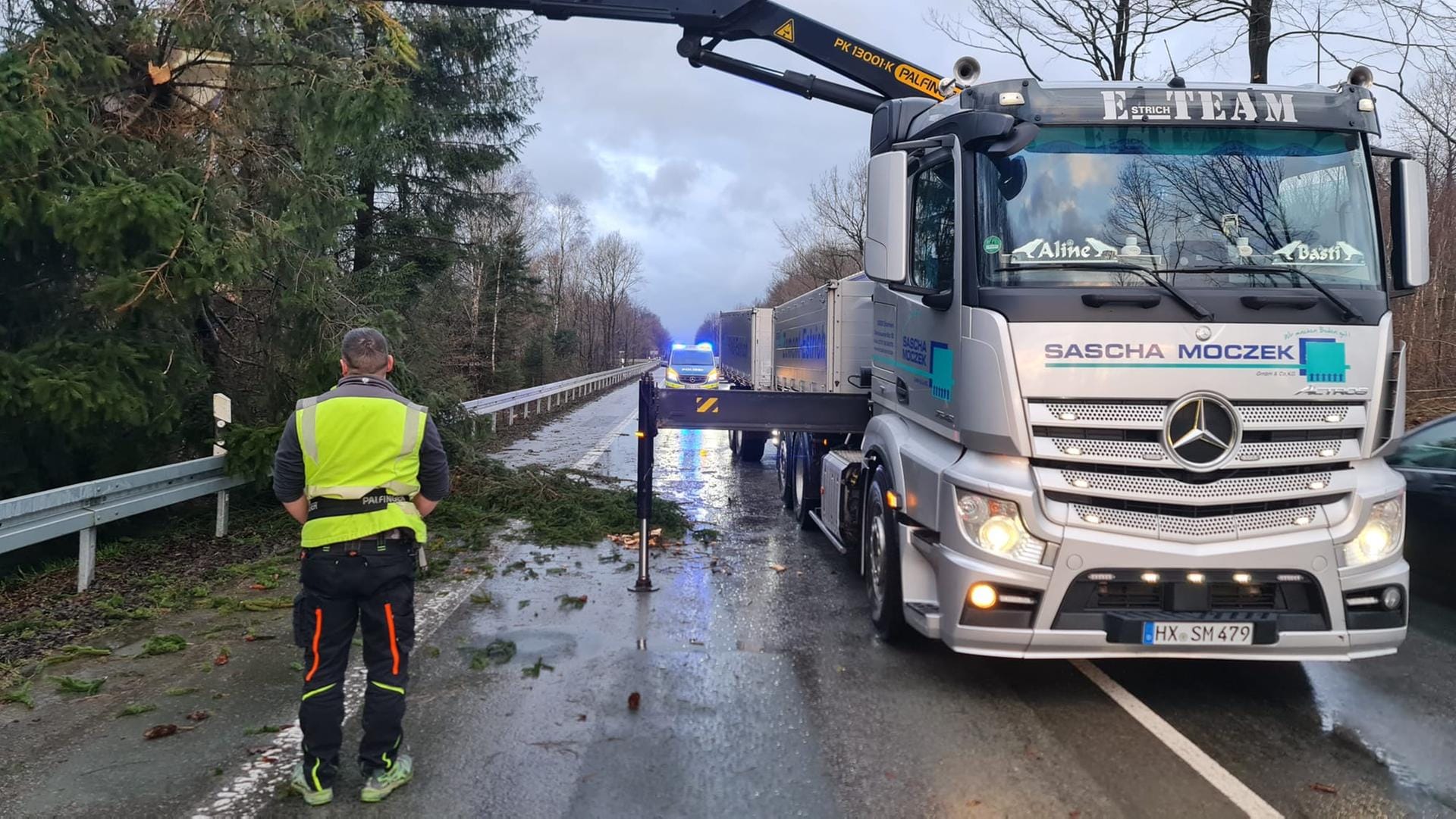 Nordrhein-Westfalen, Lichtenau: Umgestürzte Bäume sorgten auch für Behinderungen im Verkehr. Ein Lastwagenfahrer half im Kreis Paderborn den Einsatzkräften dabei, einen Stamm mit seinem Kran von der Straße zu heben.
