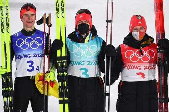 Die deutschen Nordischen Kombinierer Vinzenz Geiger (l-r), Julian Schmid und Manuel Faisst jubeln über die Silbermedaille.