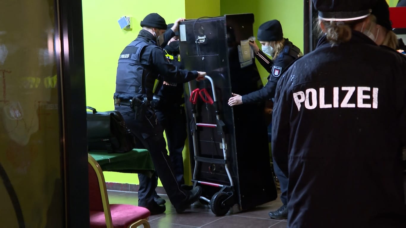 Beamte der Polizei transportieren einen Spielautomaten: Insgesamt wurden vier Automaten beschlagnahmt.