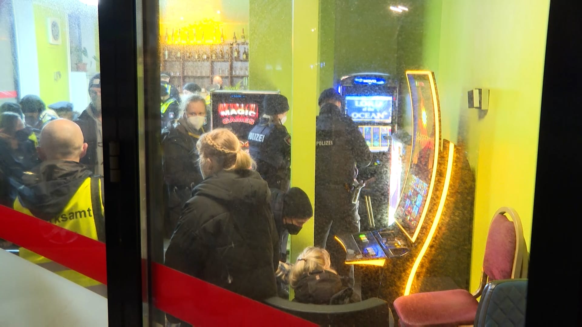Zahlreiche Beamte stehen in einem Kulturverein: Neben den illegalen Automaten stieß die Polizei auch auf Drogen und mutmaßlich gefälschte Impfpässe.