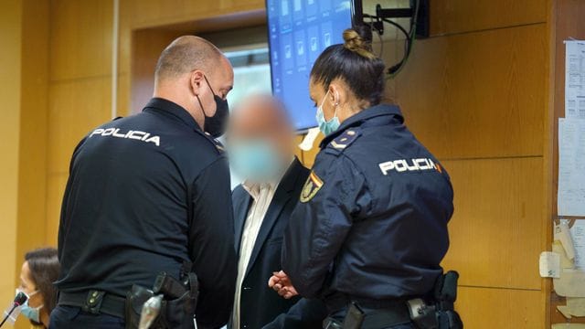 Polizeibeamte bringen den Angeklagten in den Gerichtssaal. Polizeibeamte bringen den Angeklagten in den Gerichtssaal.