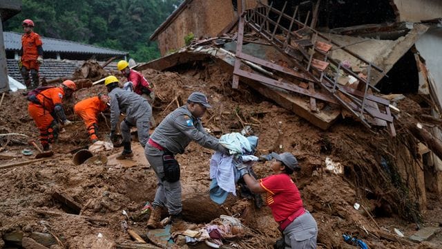 Rettungskräfte bergen am dritten Tag der Suche nach Überlebenden und Opfern der tödlichen Schlammlawinen in Petropolis Kleidung aus einem Haus. Rettungskräfte bergen am dritten Tag der Suche nach Überlebenden und Opfern der tödlichen Schlammlawinen in Petropolis Kleidung aus einem Haus.