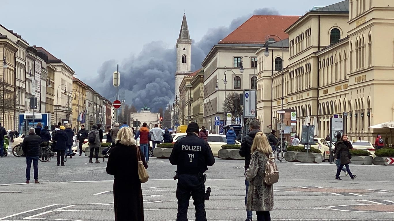 Passanten in der Innenstadt beobachten die Rauchschwaden: In Freimann hatte eine Lagerhalle Feuer gefangen.