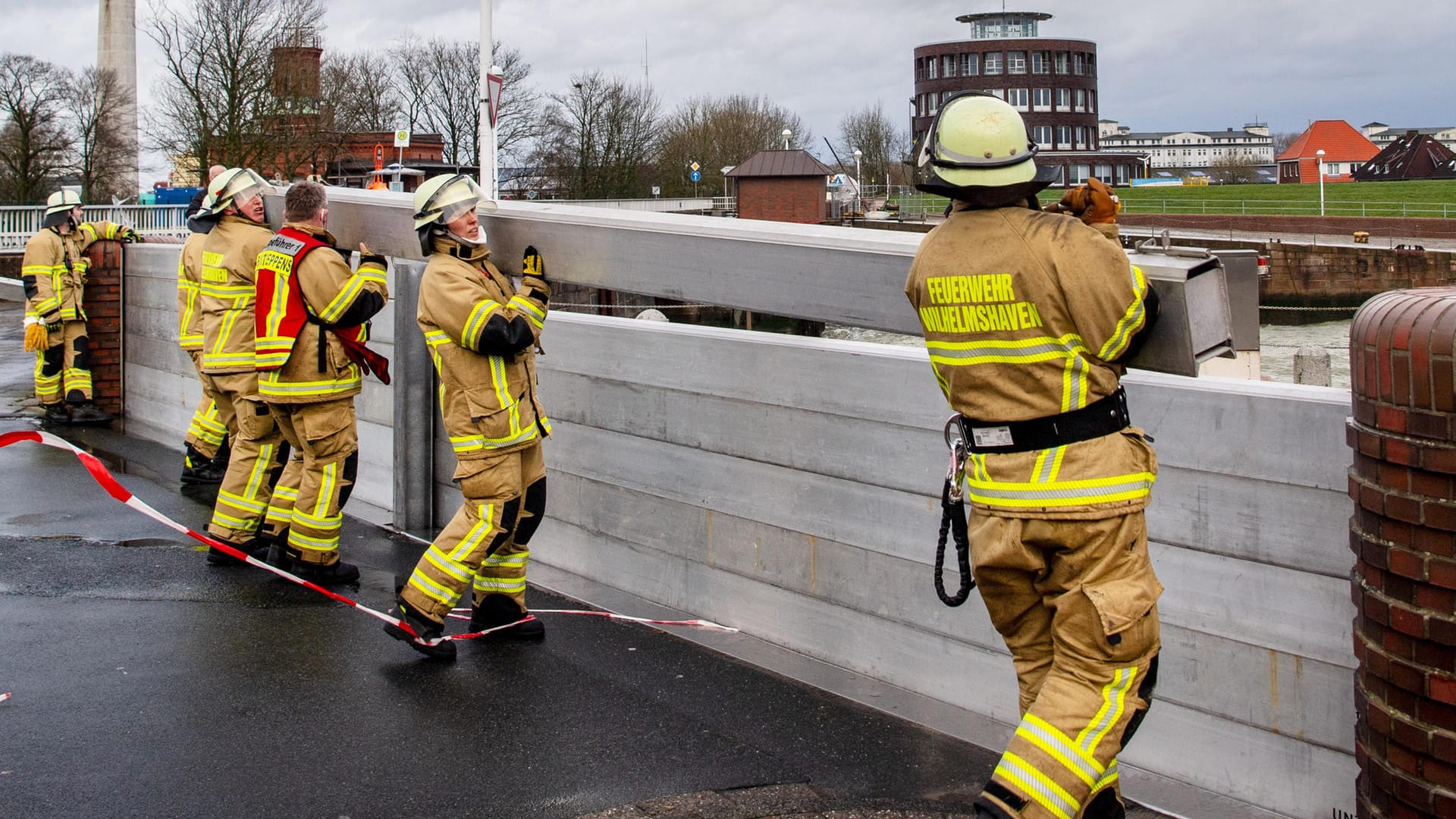 Wilhelmshaven: Einsatzkräfte der Feuerwehr haben in Vorbereitung auf eine Sturmflut den Deichschart zum Helgolandkai.