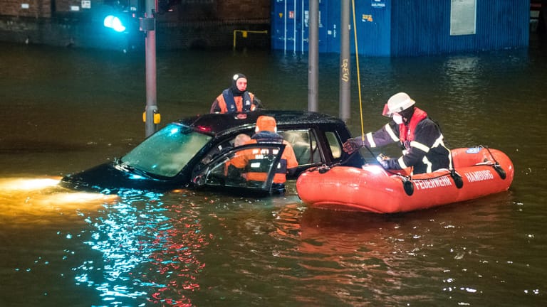 Hamburg: Feuerwehrleute retten in der Speicherstadt während einer Sturmflut beim Hochwasser der Elbe einen Mann aus seinem Auto, der zuvor versehentlich in das Wasser gefahren war.