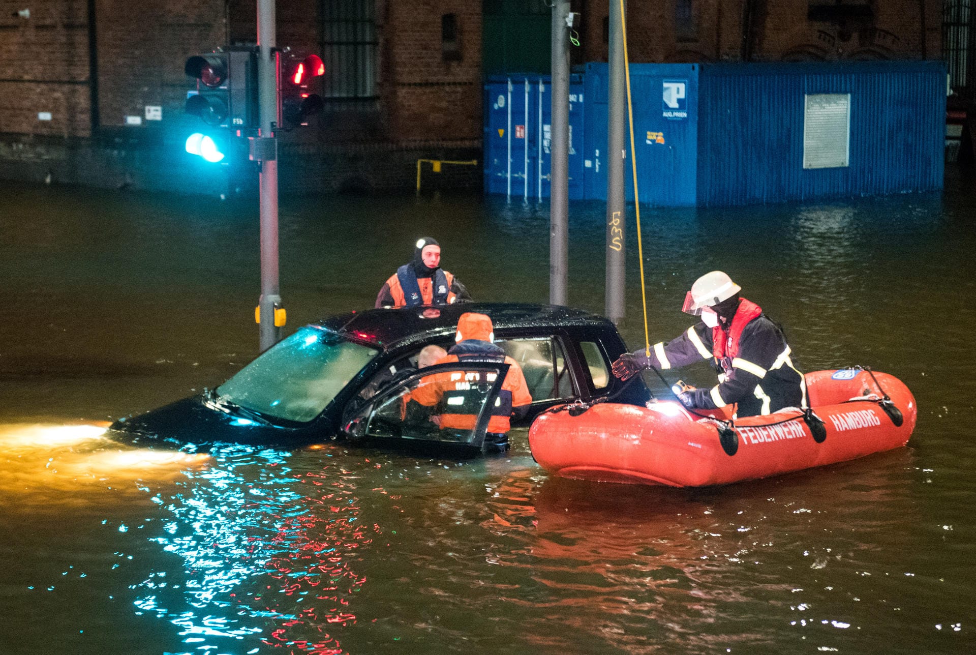Hamburg: Feuerwehrleute retten in der Speicherstadt während einer Sturmflut beim Hochwasser der Elbe einen Mann aus seinem Auto, der zuvor versehentlich in das Wasser gefahren war.