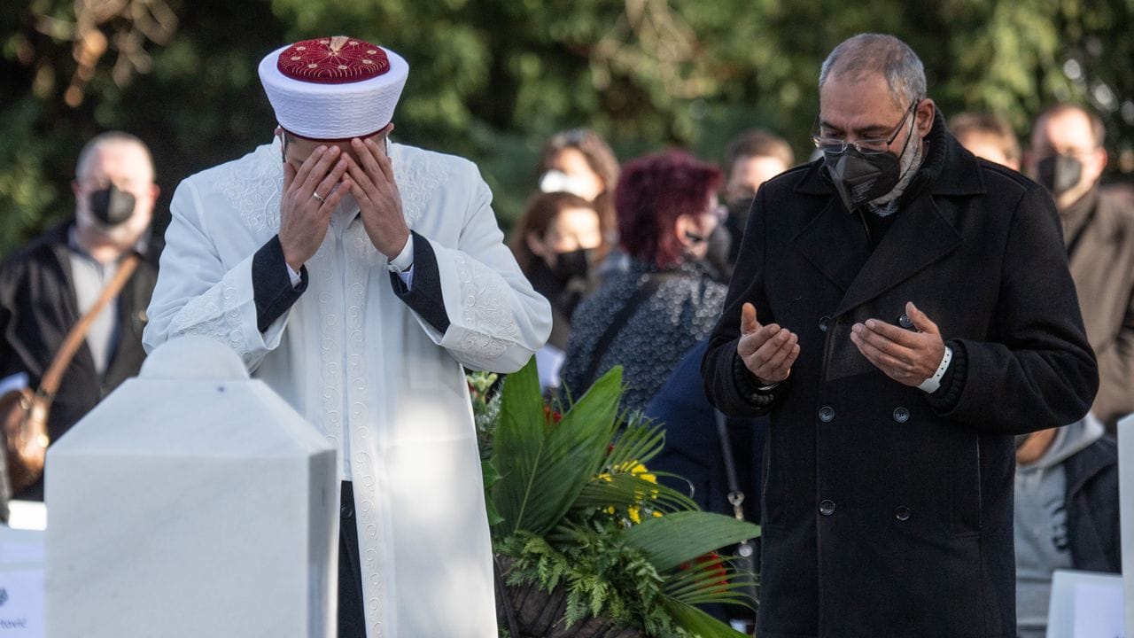 Ein Imam betet mit Angehörigen auf dem Friedhof von Hanau. Ein Imam betet mit Angehörigen auf dem Friedhof von Hanau.