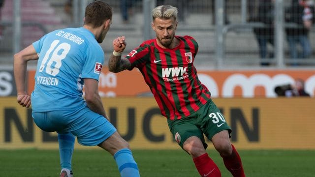 Augsburgs Niklas Dorsch (r) und Freiburgs Nils Petersen kämpfen um den Ball. Augsburgs Niklas Dorsch (r) und Freiburgs Nils Petersen kämpfen um den Ball.
