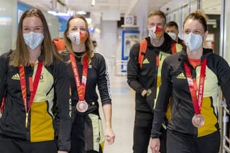 Denise Herrmann, Franziska Preuß, Roman Rees und Vanessa Hinz (l-r) kommen nach den Winterspielen am Frankfurter Flughafen an.