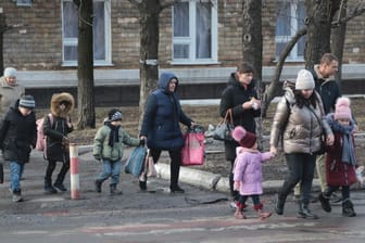Ukraine, Debaltseve: Ukrainer gehen mit Kindern zum Bahnhof, um nach Russland evakuiert zu werden.