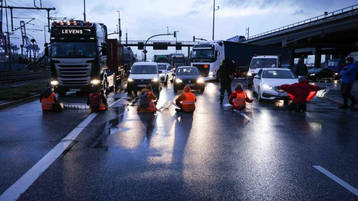 Klimaaktivisten der Aktion "Aufstand der letzten Generation" blockierten am Montagmorgen in Hamburg eine Kreuzung am Zollamt Waltershof zur Köhlbrandbrücke und zur Autobahn A7.