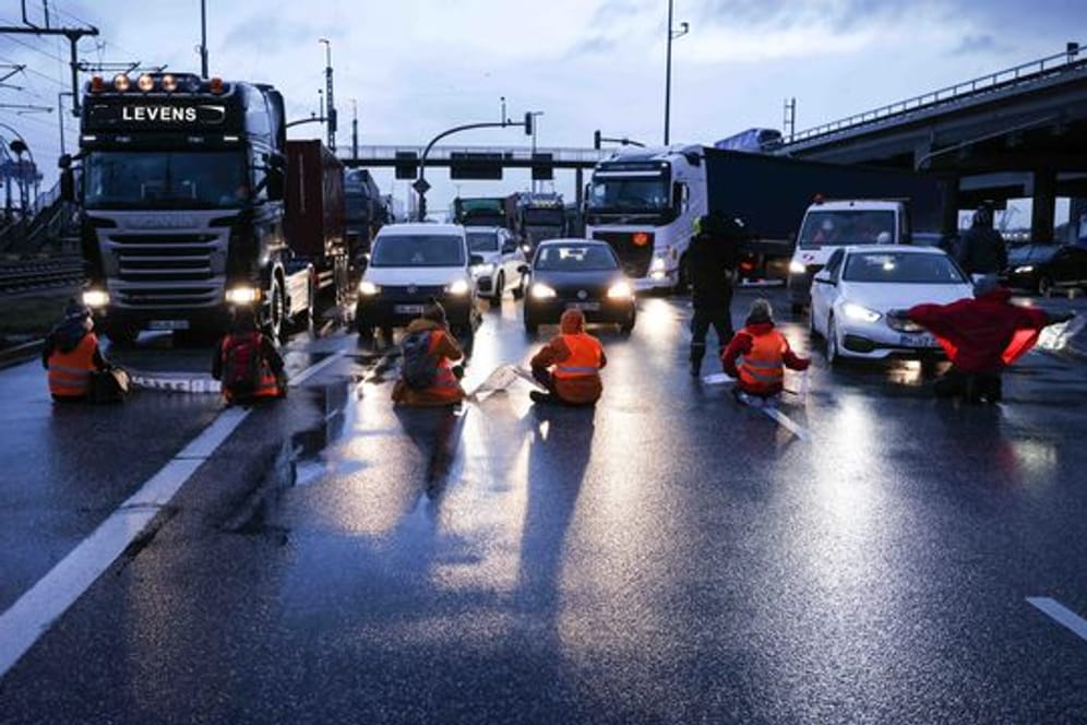 Klimaaktivisten der Aktion "Aufstand der letzten Generation" blockierten am Montagmorgen in Hamburg eine Kreuzung am Zollamt Waltershof zur Köhlbrandbrücke und zur Autobahn A7.