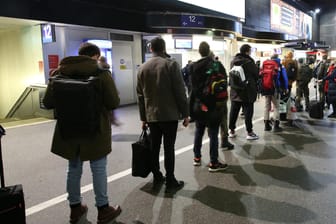Reisende stehen Schlange im Hamburger Hauptbahnhof, um an einem Schalter der Deutschen Bahn Informationen zu bekommen.