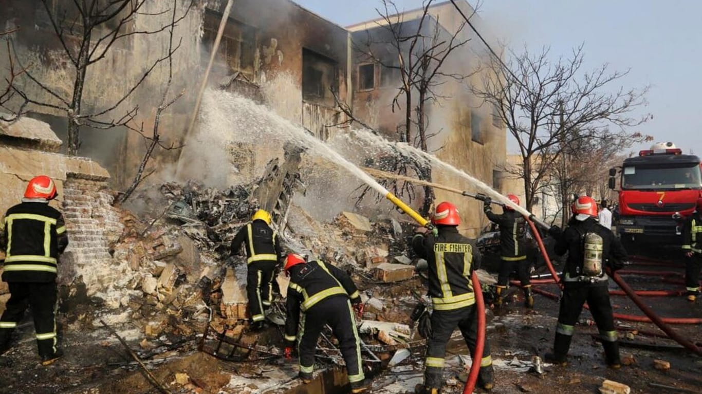Feuerwehrmänner löschen den Brand nach dem Absturz: Zwei Besatzungsmitglieder des Flugzeugs und ein Einwohner des Viertels sind getötet worden.