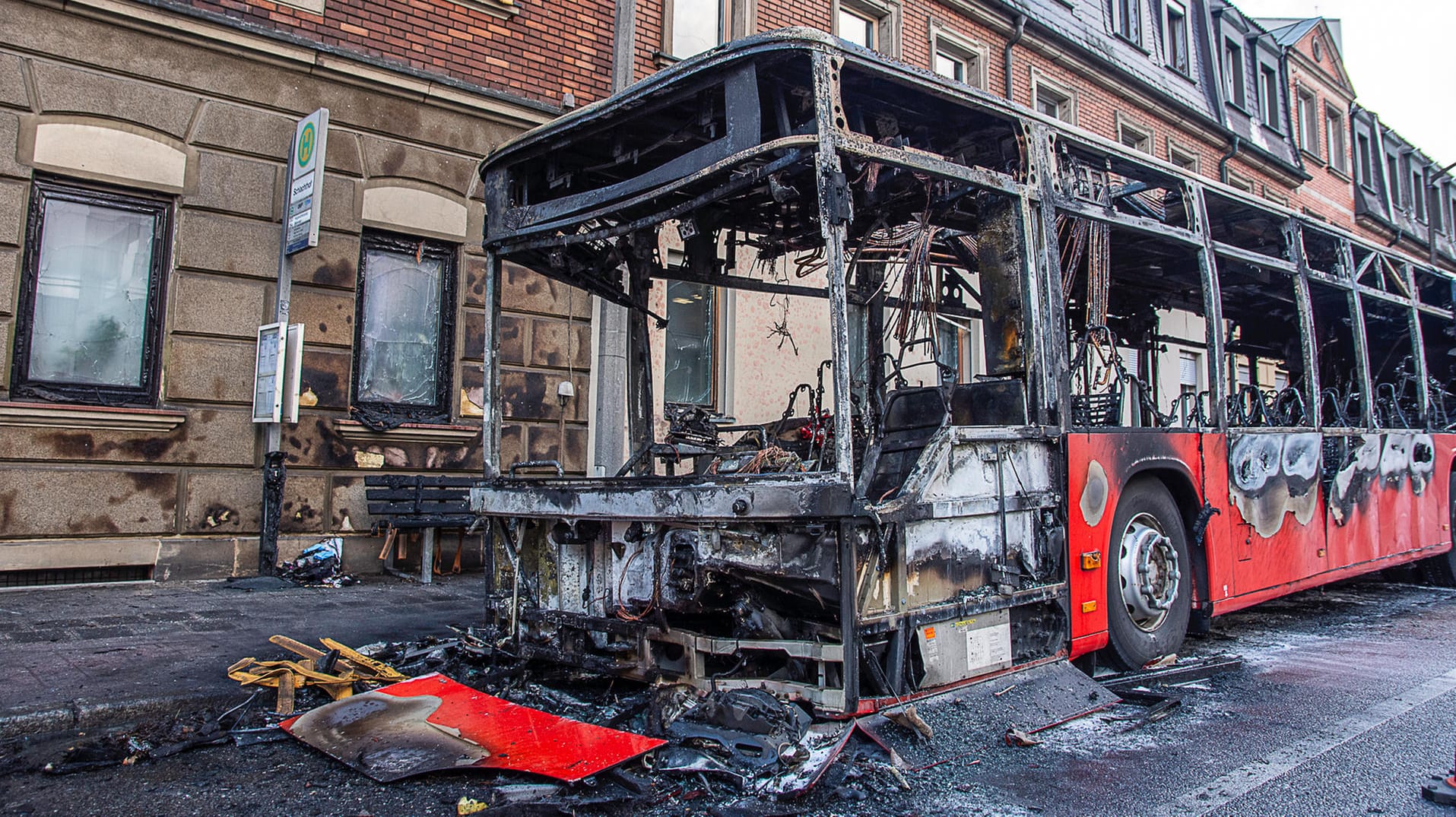 Der Bus ist komplett ausgebrannt: Auch das Gebäude nebenan wurde durch die Flammen in Mitleidenschaft gezogen. Der Bus ist komplett ausgebrannt: Auch das Gebäude nebenan wurde durch die Flammen in Mitleidenschaft gezogen.