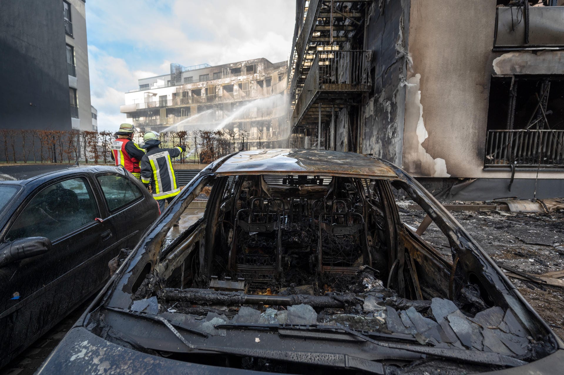 Nachlöscharbeiten am Mittag nach der Katastrophe: Auch am Gebäude stehende Autos fielen den Flammen zum Opfer.