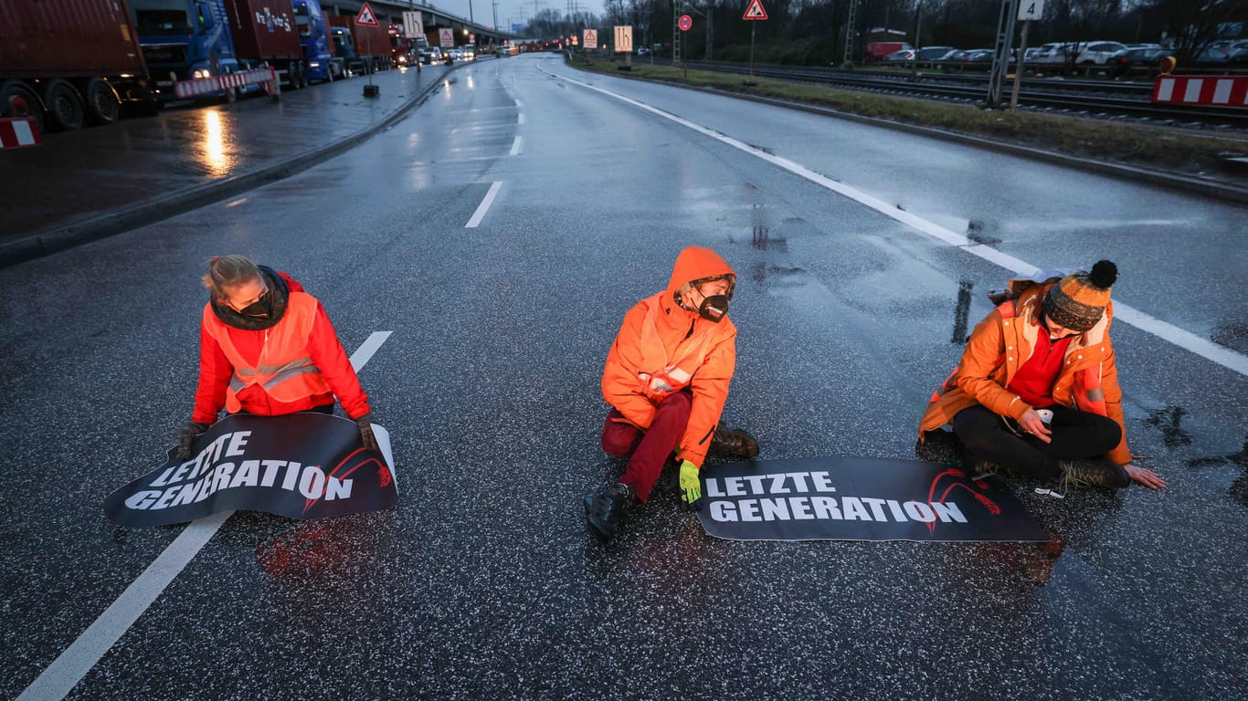 Klimaaktivisten der Aktion "Aufstand der letzten Generation" blockieren am Morgen eine Kreuzung am Zollamt Waltershof zur Köhlbrandbrücke und zur Autobahn A7