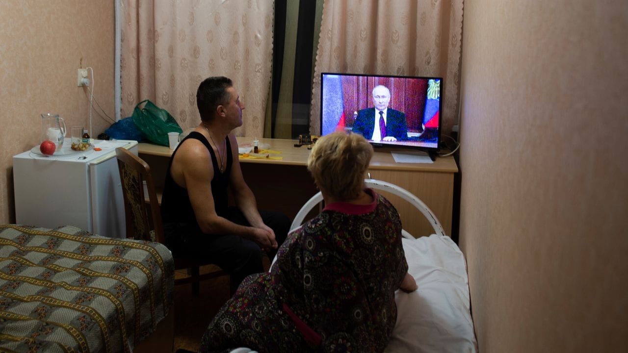Menschen verfolgen die Fernsehansprache des russischen Präsidenten Putin. Menschen verfolgen die Fernsehansprache des russischen Präsidenten Putin.