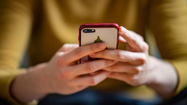 Eine Frau hält ein Smartphone in den Händen