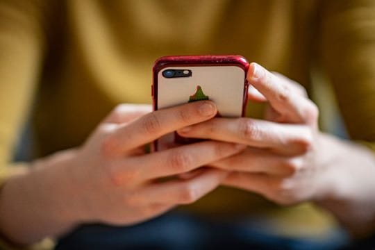 Eine Frau hält ein Smartphone in den Händen