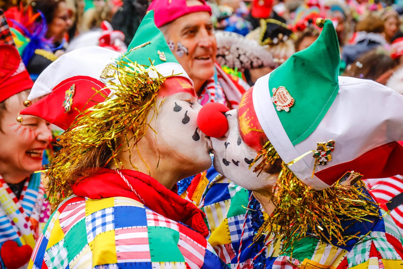 Zwei verkleidete Menschen geben sich einen Kuss (Symbolbild): Das "Bützen" gehört eigentlich fest zum Karneval in Köln dazu. Kölns OB Henriette Reker mahnt trotz weitreichender Lockerungen aber zur Zurückhaltung.