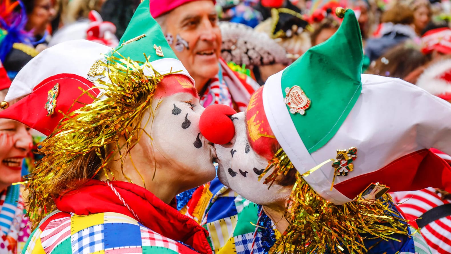 Zwei verkleidete Menschen geben sich einen Kuss (Symbolbild): Das "Bützen" gehört eigentlich fest zum Karneval in Köln dazu. Kölns OB Henriette Reker mahnt trotz weitreichender Lockerungen aber zur Zurückhaltung. Zwei verkleidete Menschen geben sich einen Kuss (Symbolbild): Das "Bützen" gehört eigentlich fest zum Karneval in Köln dazu. Kölns OB Henriette Reker mahnt trotz weitreichender Lockerungen aber zur Zurückhaltung.
