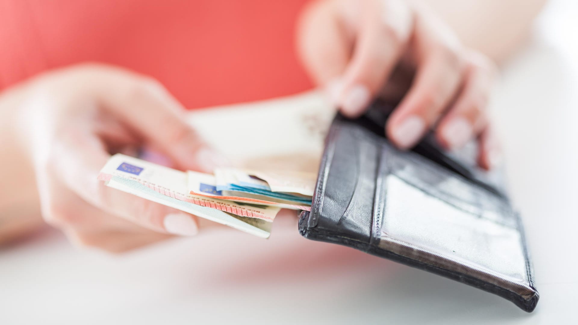 Eine Frau zieht Geldscheine aus dem Portemonnaie (Symbolbild): Unternehmen können ihren Beschäftigten noch bis Ende März einen steuerfreien Corona-Bonus zahlen.