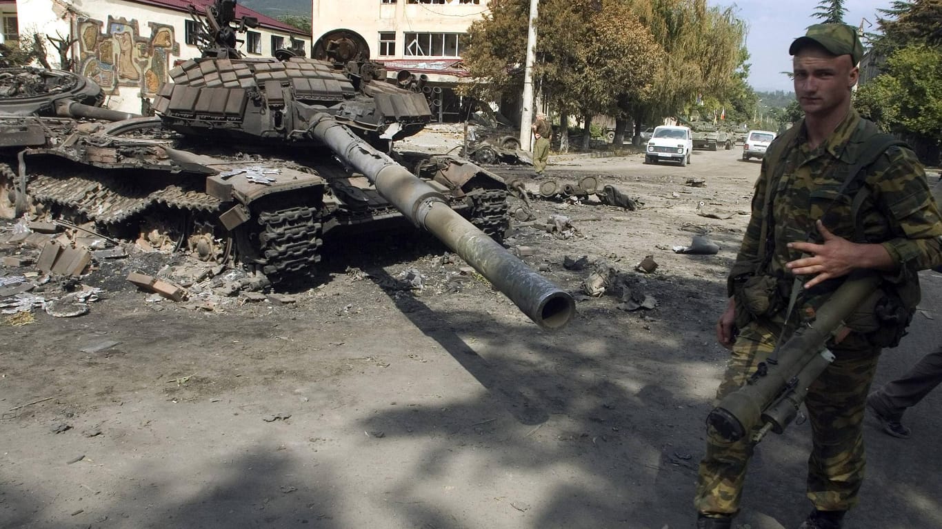 Russischer Soldat vor dem Wrack eines ausgebrannten georgischen Panzers in Zchinwali im August 2008: Beim aktuellen Geschehen in der Ukraine gibt es Parallelen zum Kaukasuskrieg.
