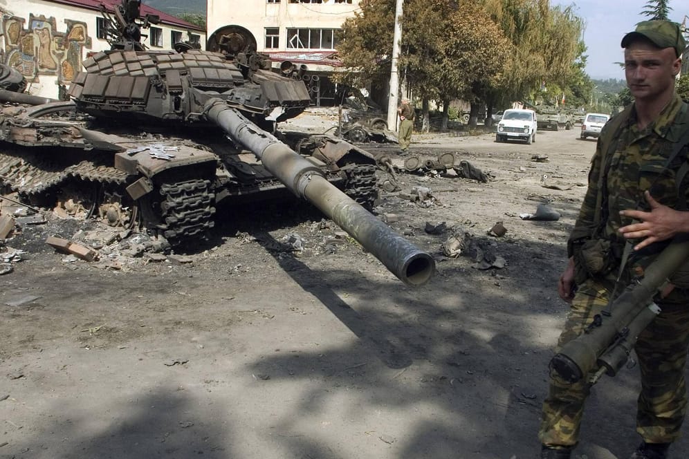 Russischer Soldat vor dem Wrack eines ausgebrannten georgischen Panzers in Zchinwali im August 2008: Beim aktuellen Geschehen in der Ukraine gibt es Parallelen zum Kaukasuskrieg.