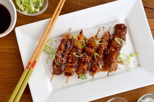 Die Teriyaki-Soße aus Sojasoße, Mirin und Sake und eine große Portion Zucker sorgen dafür, dass das Fleisch der Yakitori-Spieße schön glänzt und beim Grillen zart bleibt.