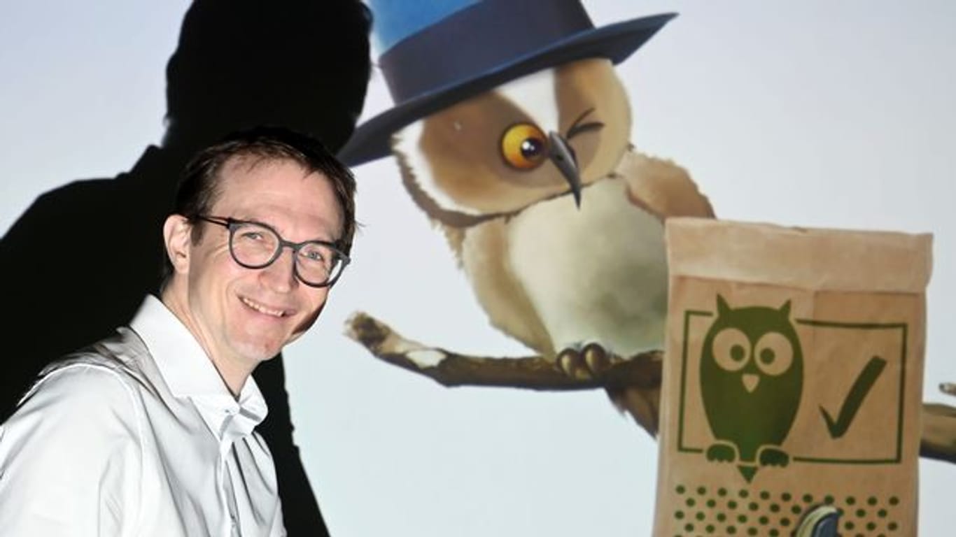 Jan Reichert, Geschäftsführer der Firma kr3m, im Hintergrund die App "Klima Buddy" mit einem Waldkauz.